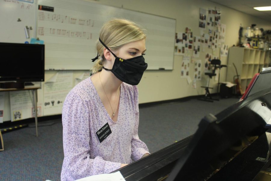 Upper School music teacher, Hannah Crowley sits at the piano preparing a lesson before students arrive.